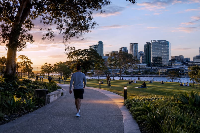 A man walking with the Bupa building in the background 